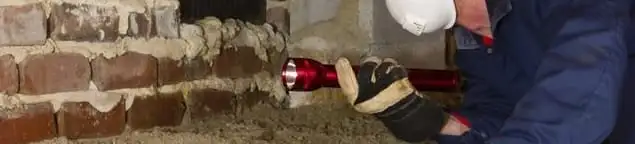Pest control technician inspecting a crawl space for ant activity and entry points in Glendale, AZ